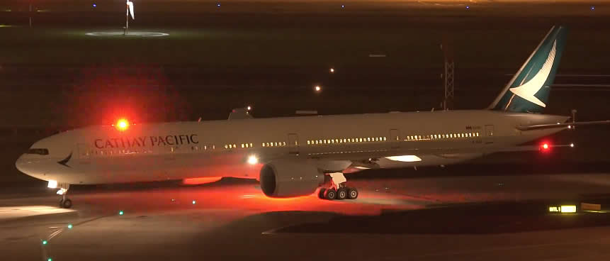 Boeing 777 of Cathay Pacific with red anti-collision flashing lights on top and bottom of fuselage