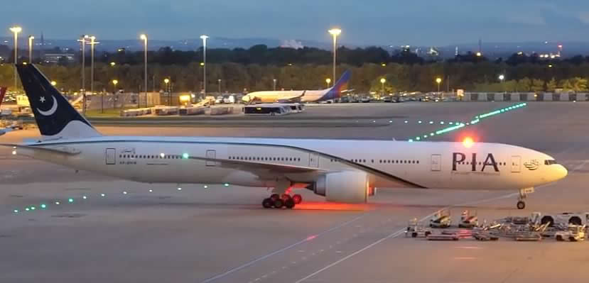 PIA Boeing 777-300 at the gate at night
